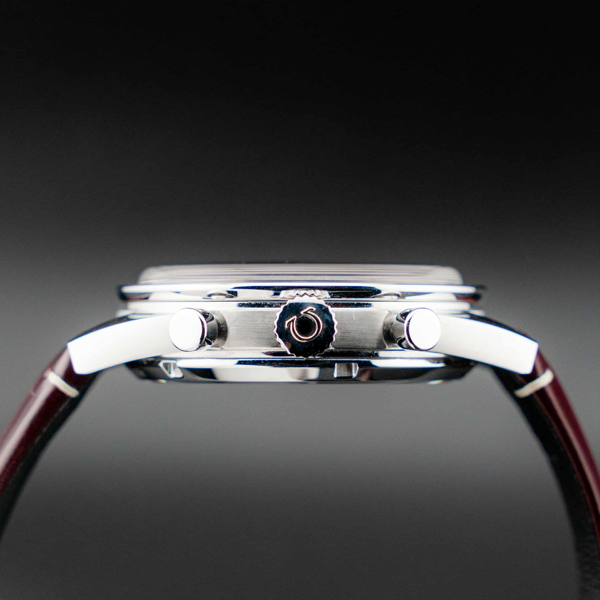 Omega Speedmaster '57 Burgundy full set side view showcasing the case and chronograph buttons.