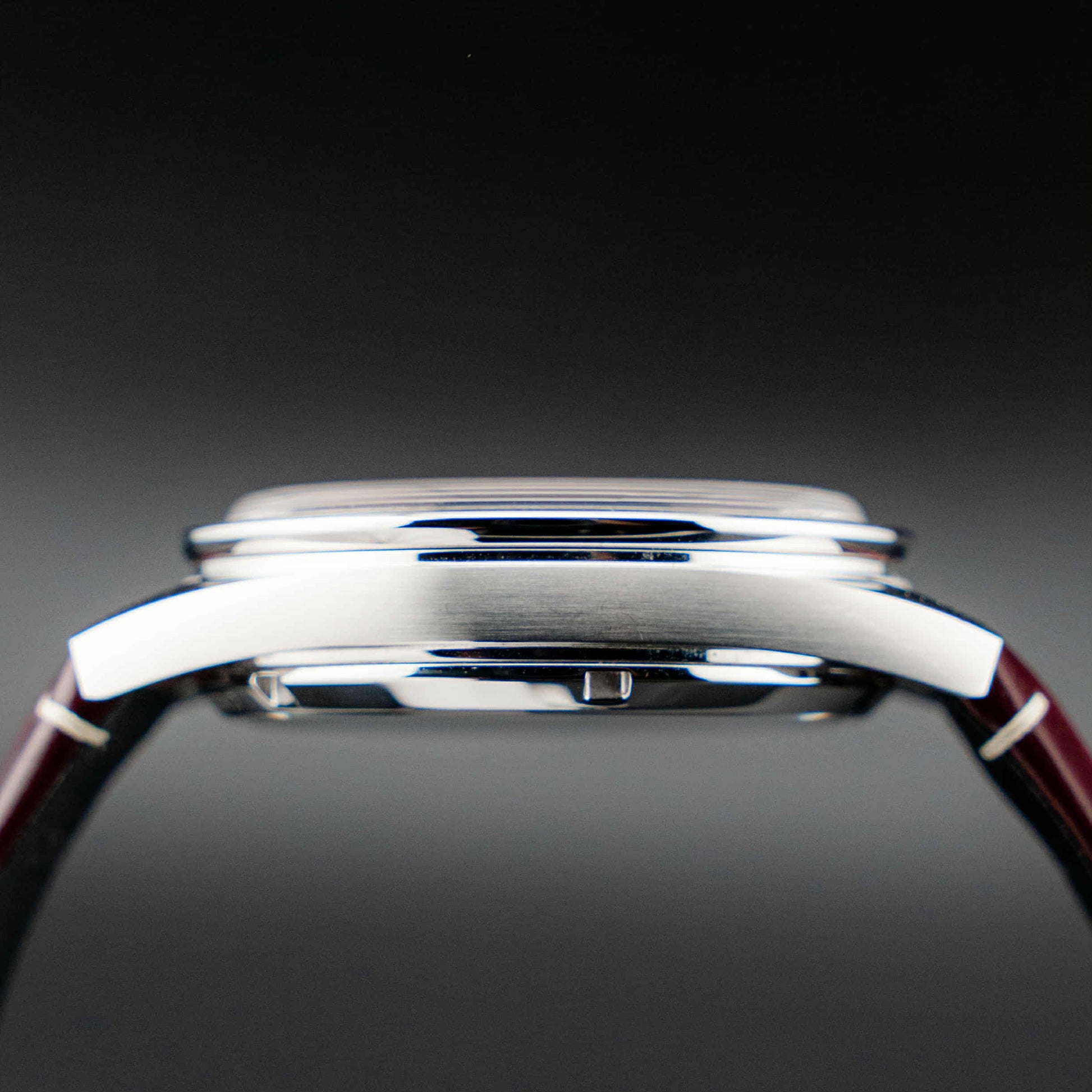 Omega Speedmaster '57 Burgundy full set side profile showing case and strap design.