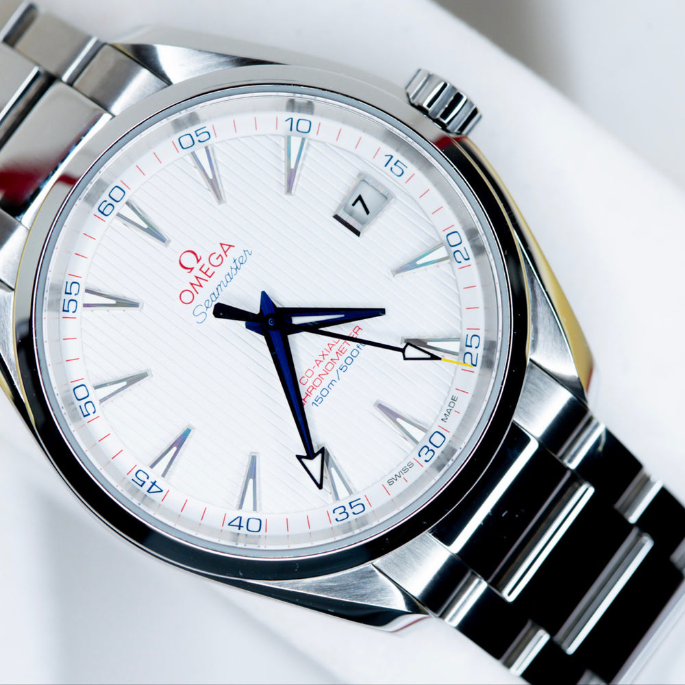 2018 Omega Seamaster Aqua Terra watch displayed on a white cushion, featuring a bright opaline dial and red accents.