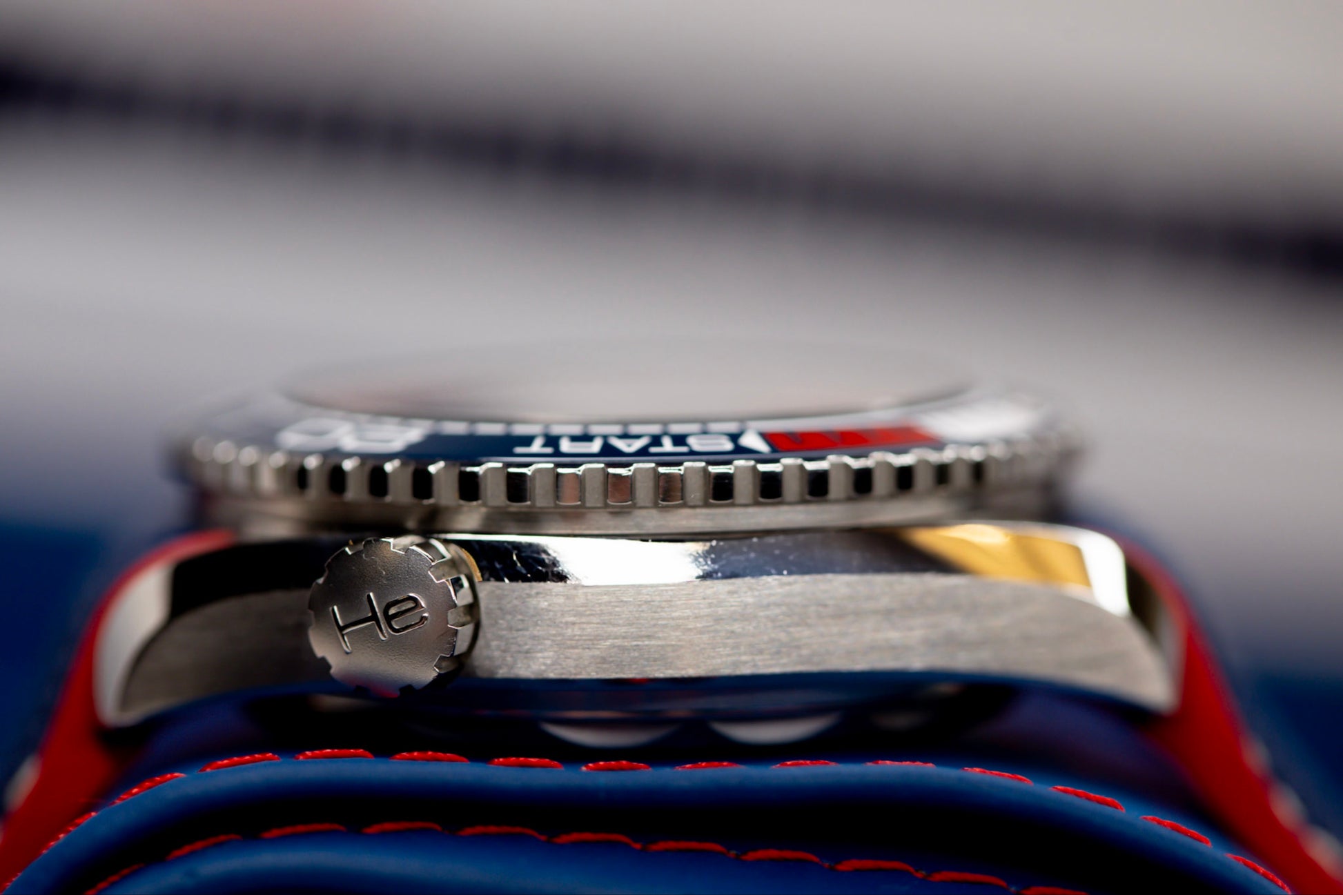 Omega Seamaster America's Cup watch close-up showing side view of the steel case and helium escape valve.