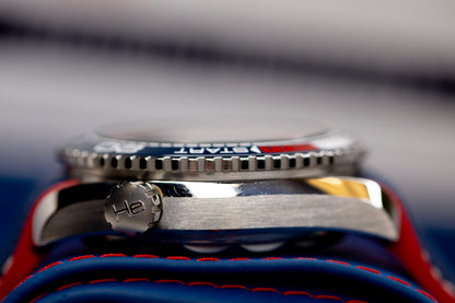 Omega Seamaster America's Cup watch close-up showing side view of the steel case and helium escape valve.