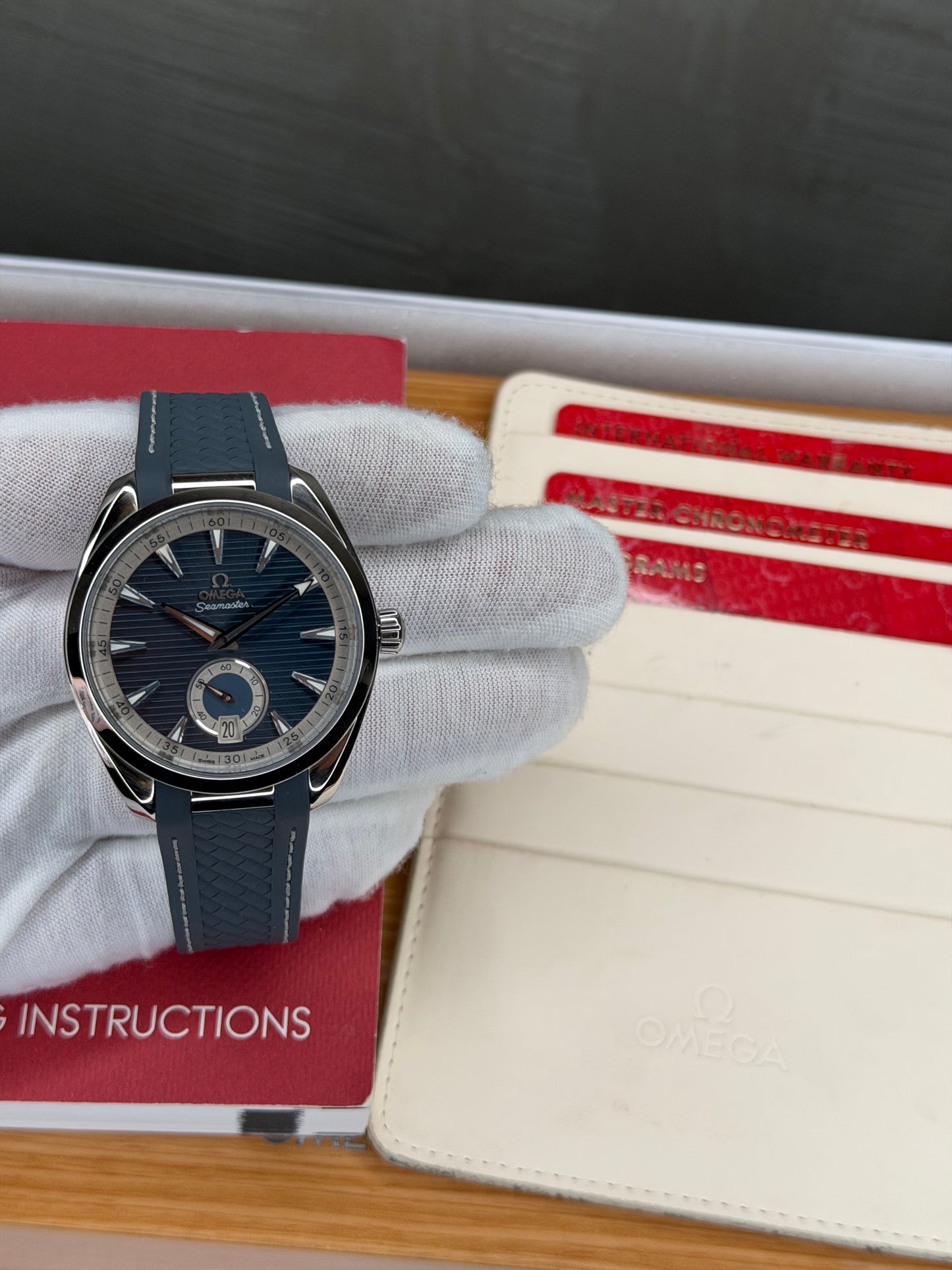 Omega Seamaster Aqua Terra 150M blue dial displayed with its full set instructions and warranty cards.