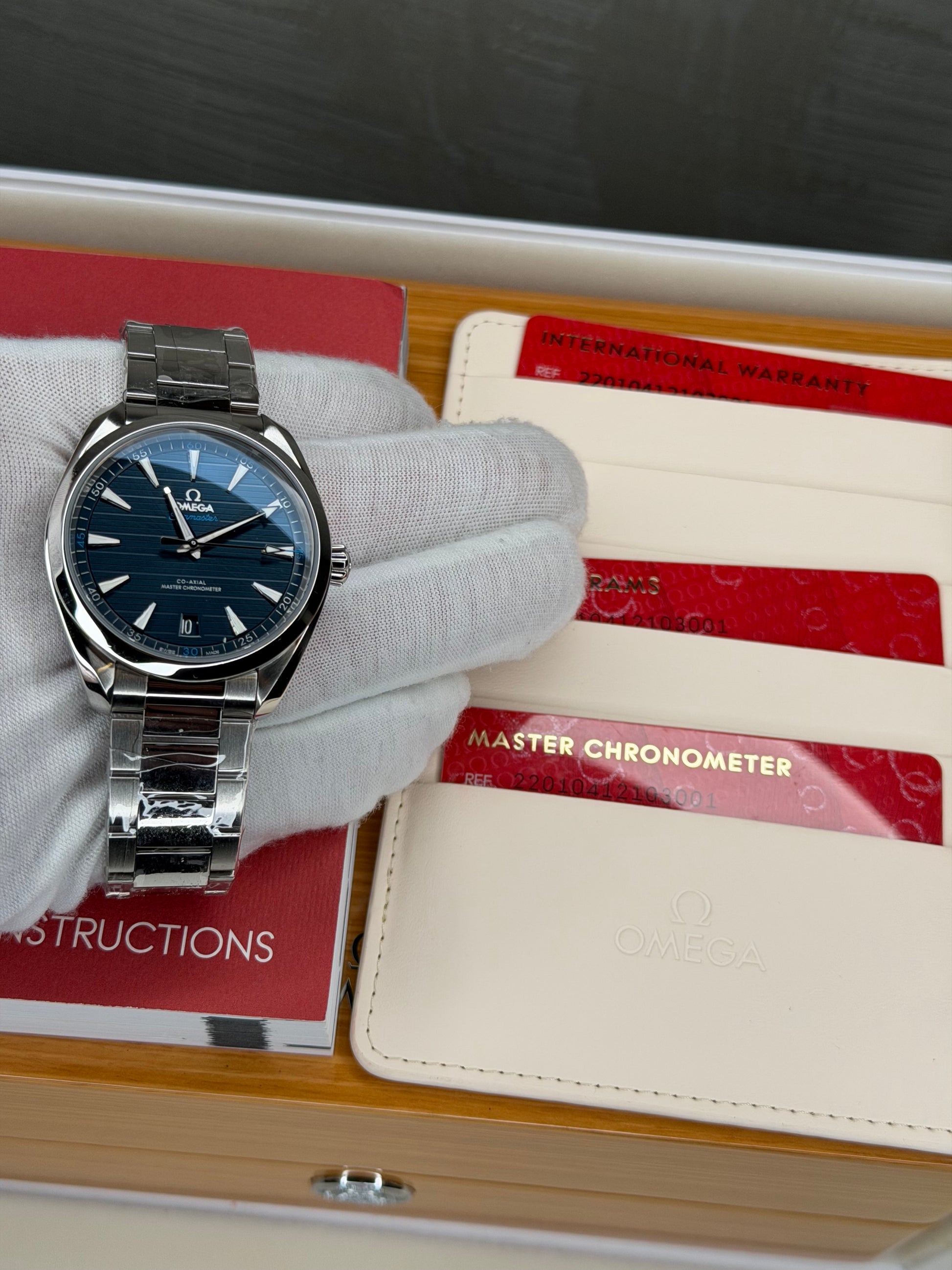 Omega Seamaster Aqua Terra 41mm watch displayed with international warranty and instructions.