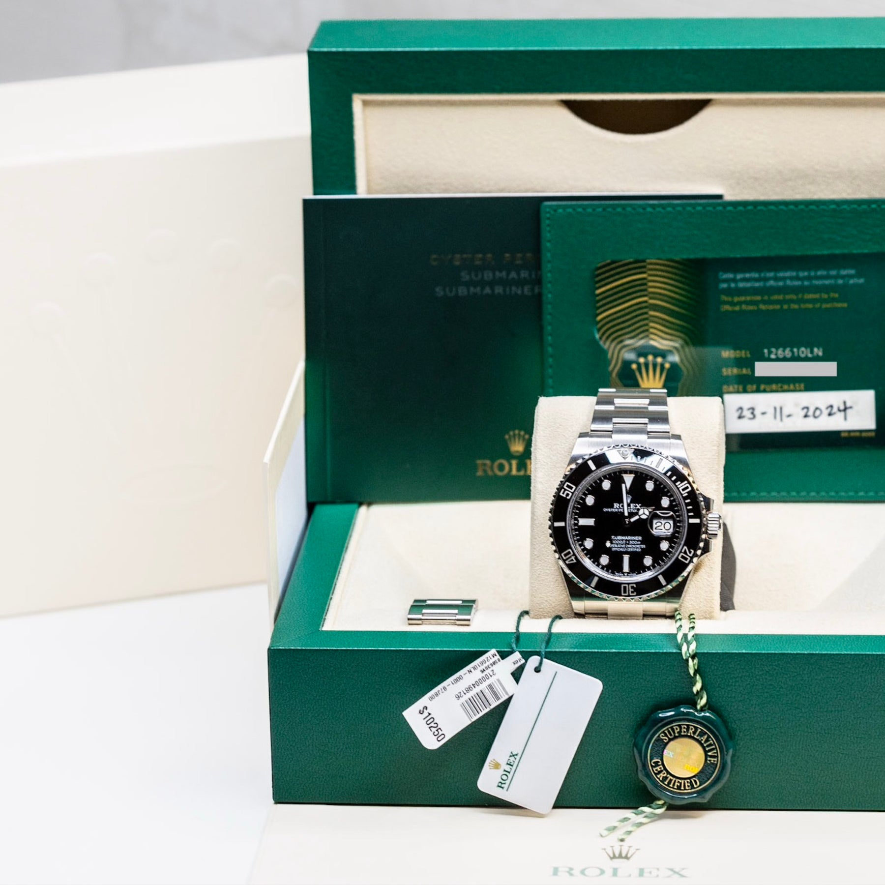 2025 Rolex Submariner Date black watch displayed in its original green box with accessories.