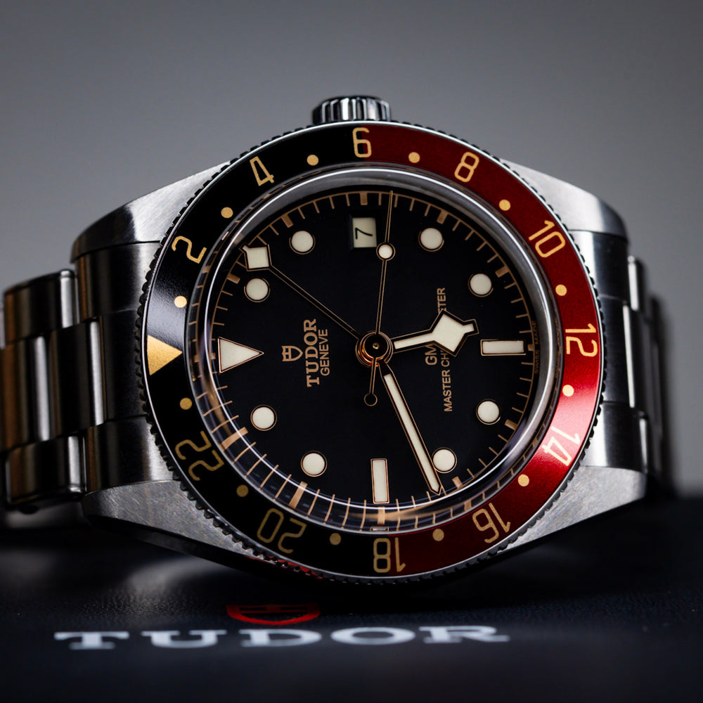 2025 Tudor Black Bay 58 GMT watch on a stainless steel bracelet with a black dial and red bezel.