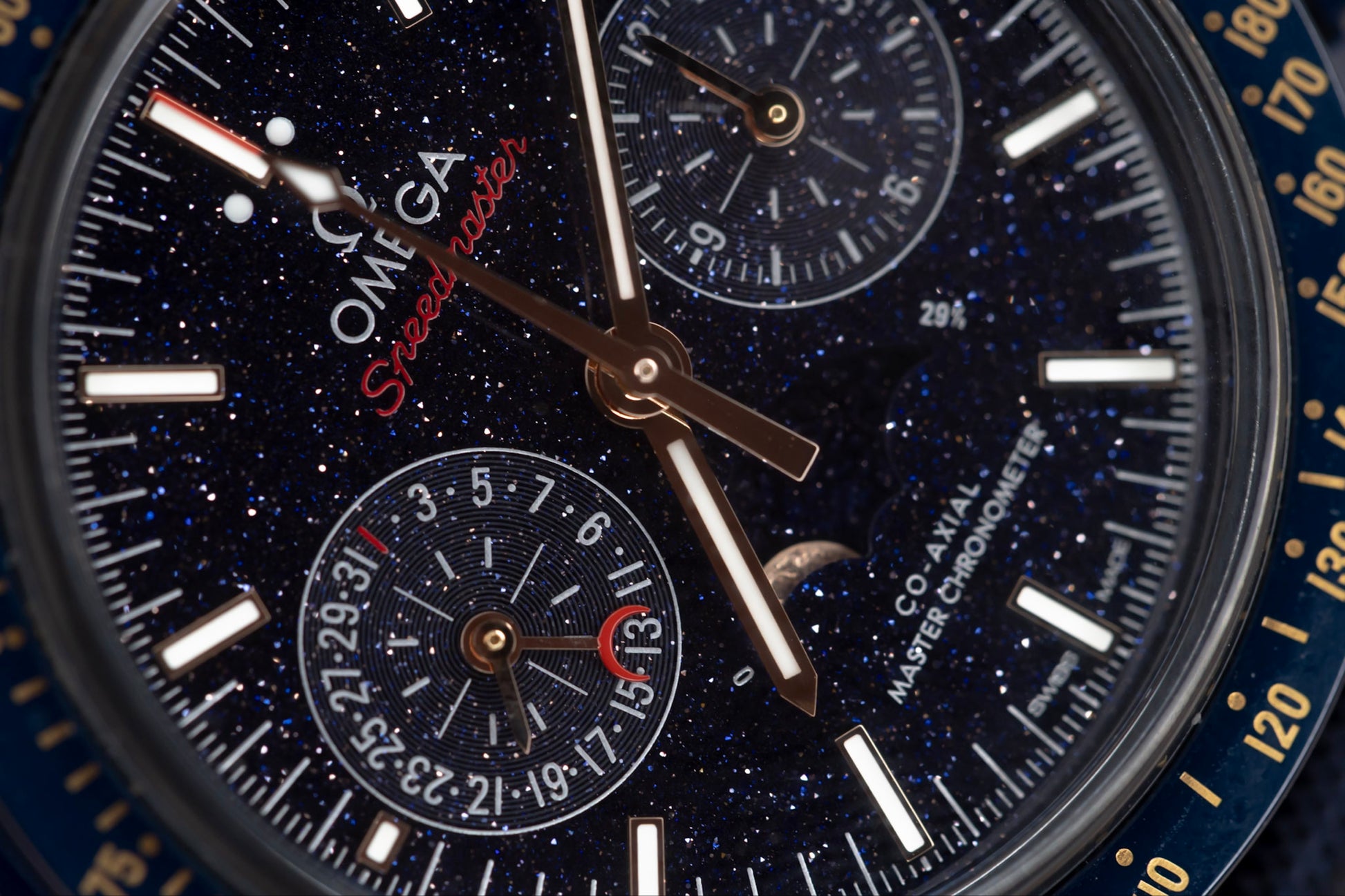 Close-up of the Omega Speedmaster Blue Side of the Moon watch dial featuring aventurine glass and 18K Sedna gold elements.