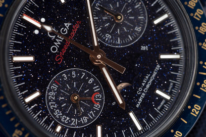 Close-up of the Omega Speedmaster Blue Side of the Moon watch dial featuring aventurine glass and 18K Sedna gold elements.