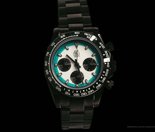 The Voyager Chronograph watch by Kingdom Watch Company featuring a black strap and white dial with turquoise accents.